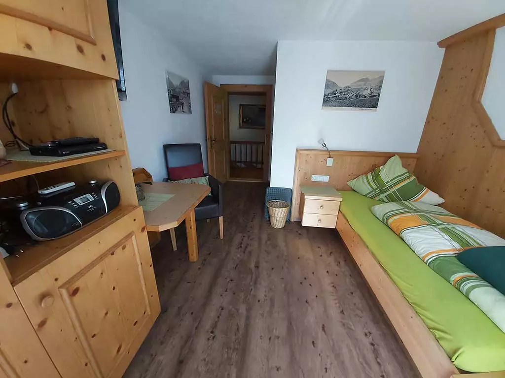 Zimmer mit Einzelbett, Holzboden und Balkon am Messnerhof in Virgen